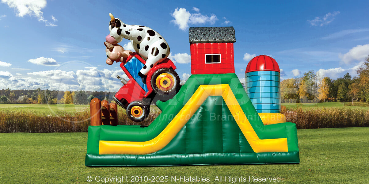 Side view of the Barnyard Breakout 180 obstacle with inflatable barn, silo, and farm animals. 