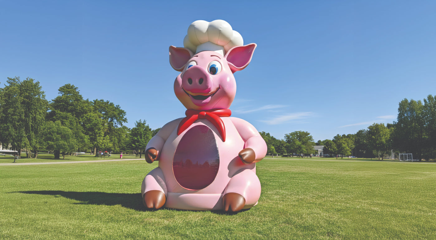 Front View of BBQ Pig Inflatable Bounce House setup on grass surface