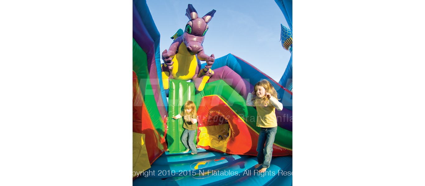 Kid s bouncing inside the Castle Fun Centre™ inflatable playground with a purple dragon above. 