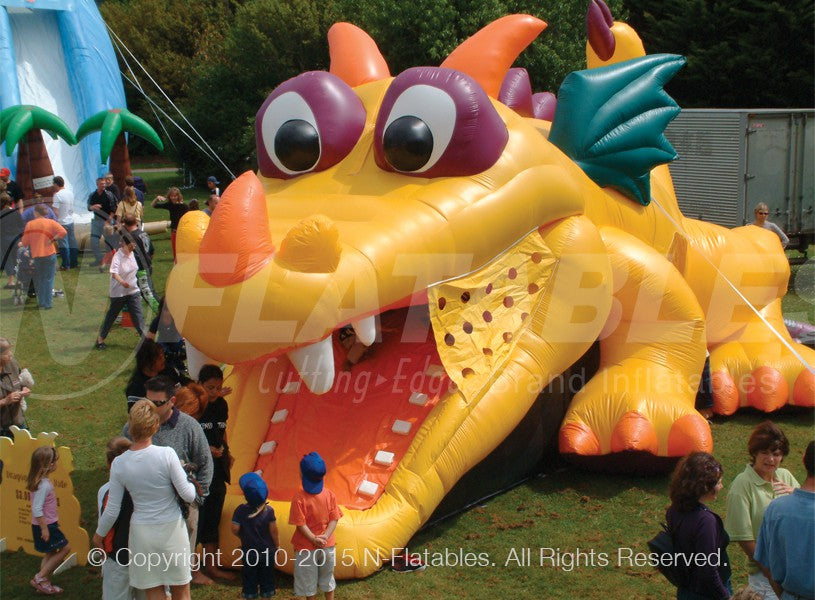 The Dragon Hide-n-Slide™ inflatable combo set up at an outdoor event with a crowd around. 