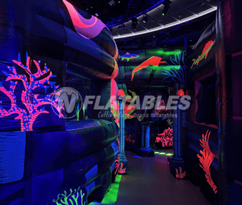 Inside of an ocean-themed inflatable blacklight reactive laser tag maze. 