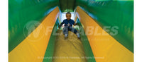 Boy sliding down the Rainforest Fun Center inflatable playground.