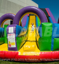A kid sliding down the Wacky Slide Combo™ inflatable playground. 
