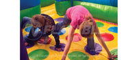 Two kids playing inside the bouncing area of the Wacky World inflatable combo 