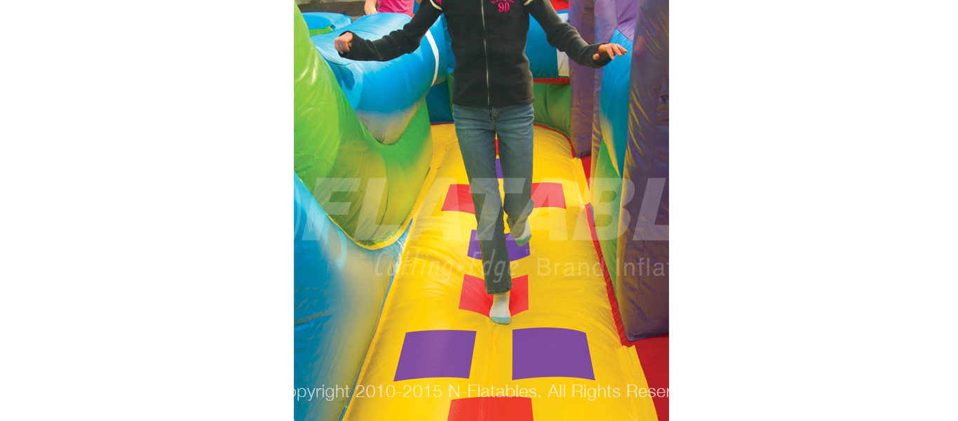 Kid playing hopscotch inside the Wacky World inflatable bounce house and slide combo. 